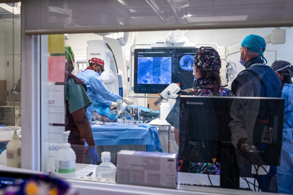 Dr. Andrew Brown flushes the tubing with saline to push the radioactive beads forward, towards the tumour in Dave McManus’ liver.